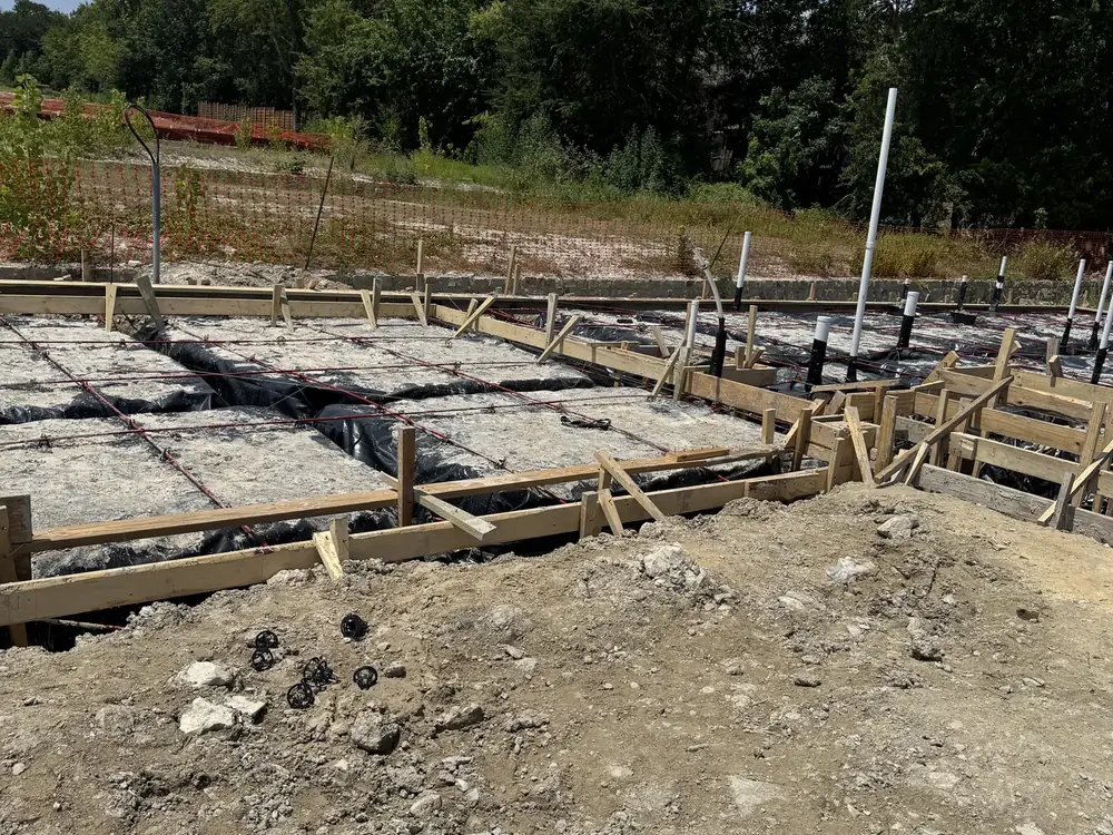 New home slab foundation with underground plumbing rough-in stub-outs on an Eco Water Solutions jobsite