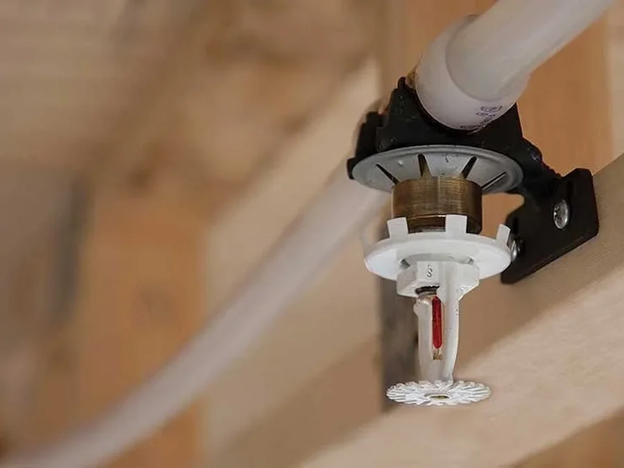Multipurpose residential fire sprinkler head connected to PEX piping on wood framing in a new Texas home